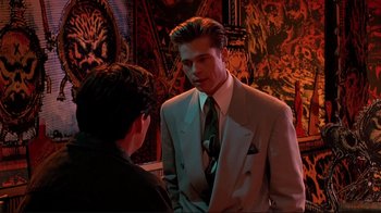 Movie still from “Cool World” (1992), directed by Ralph Bakshi – A man in a suit talking to another man in a suit; Medium shot, Over the shoulder angle