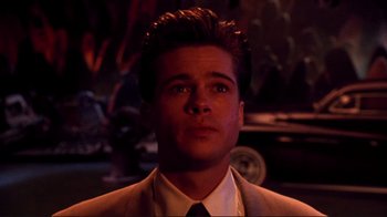 Movie still from “Cool World” (1992), directed by Ralph Bakshi – A man in a suit and tie looking to his left; Close Up shot, Over the shoulder angle