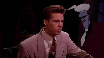 Movie still from “Cool World” (1992), directed by Ralph Bakshi – A man in a suit and tie sitting in front of an animated character; Medium shot, Over the shoulder angle