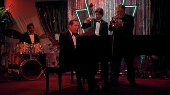 Movie still from “Cool World” (1992), directed by Ralph Bakshi – A group of men in tuxedos playing musical instruments; Wide shot, Low angle