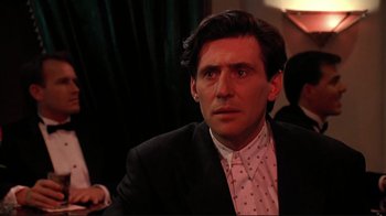 Movie still from “Cool World” (1992), directed by Ralph Bakshi – A person wearing a suit and tie; Close Up shot, Over the shoulder angle