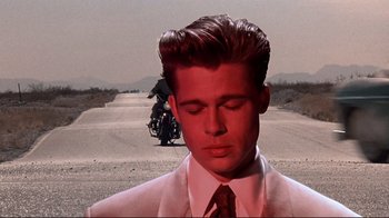 Movie still from “Cool World” (1992), directed by Ralph Bakshi – A man in a white suit and a red tie standing in the middle of a road; Close Up shot, Over the shoulder angle