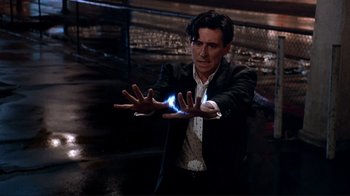 Movie still from “Cool World” (1992), directed by Ralph Bakshi – A man in a black suit is holding something in his hands; Medium shot, High angle