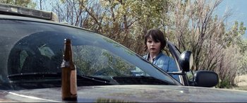 Movie still from “Cop Car” (2015), directed by Jon Watts – A young boy sitting in the driver's seat of a parked car; Medium shot, Over the shoulder angle