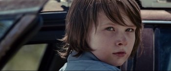 Movie still from “Cop Car” (2015), directed by Jon Watts – A young boy's face with long brown hair; Close Up shot, Over the shoulder angle