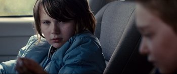 Movie still from “Cop Car” (2015), directed by Jon Watts – A young girl sitting in the back seat of a car; Close Up shot, Over the shoulder angle