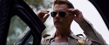 Movie still from “Cop Car” (2015), directed by Jon Watts – A person wearing sunglasses; Close Up shot, Low angle