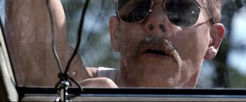 Movie still from “Cop Car” (2015), directed by Jon Watts – An old man with a mustache and a mustache brush in his mouth; Close Up shot, Low angle