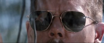 Movie still from “Cop Car” (2015), directed by Jon Watts – A man's face wearing a pair of sunglasses; Extreme Close Up shot, Low angle