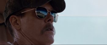 Movie still from “Cop Car” (2015), directed by Jon Watts – A person wearing a hat and sunglasses; Close Up shot, Low angle