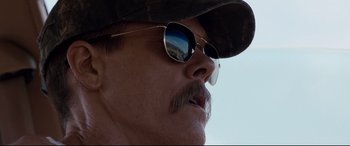 Movie still from “Cop Car” (2015), directed by Jon Watts – A person wearing sunglasses and a hat; Close Up shot, Low angle
