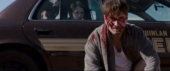 Movie still from “Cop Car” (2015), directed by Jon Watts – A man and a woman in the back of a car; Medium shot, Over the shoulder angle