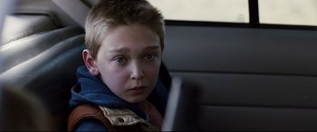 Movie still from “Cop Car” (2015), directed by Jon Watts – A young boy is looking at a computer screen; Close Up shot, Over the shoulder angle