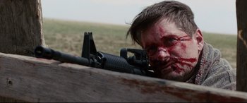 Movie still from “Cop Car” (2015), directed by Jon Watts – A man with blood all over his face and a rifle; Close Up shot, Over the shoulder angle