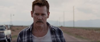 Movie still from “Cop Car” (2015), directed by Jon Watts – A person wearing a plaid shirt; Close Up shot, Over the shoulder angle
