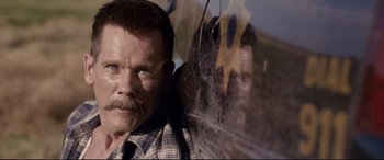 Movie still from “Cop Car” (2015), directed by Jon Watts – A person with a mustache; Close Up shot, Over the shoulder angle