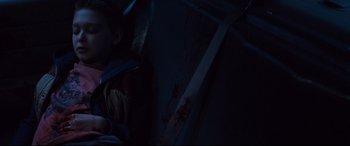 Movie still from “Cop Car” (2015), directed by Jon Watts – A person with blood on their face and a knife in their hand; Close Up shot, High angle