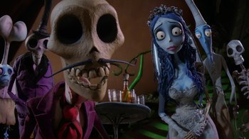 Movie still from “Corpse Bride” (2005), directed by Tim Burton – A couple of figurines are sitting next to each other; Medium shot, Low angle