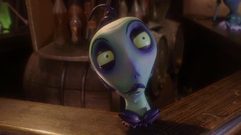 Movie still from “Corpse Bride” (2005), directed by Tim Burton – An alien figurine sitting on top of a wooden table; Close Up shot, High angle