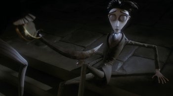 Movie still from “Corpse Bride” (2005), directed by Tim Burton – A creepy looking animated character is sitting on the ground; Medium shot, High angle