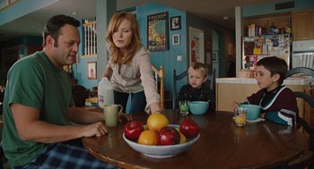 Movie still from “Couples Retreat” (2009), directed by Peter Billingsley – A woman standing at a table with a bowl of fruit; Medium shot, Over the shoulder angle