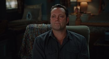 Movie still from “Couples Retreat” (2009), directed by Peter Billingsley – A man sitting on a couch in a living room; Close Up shot, High angle