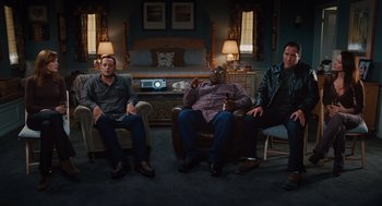 Movie still from “Couples Retreat” (2009), directed by Peter Billingsley – A group of men sitting in a living room next to each other; Wide shot, High angle