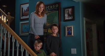 Movie still from “Couples Retreat” (2009), directed by Peter Billingsley – A woman and two boys standing on the stairs of a house; Medium shot, Over the shoulder angle