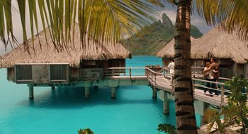 Movie still from “Couples Retreat” (2009), directed by Peter Billingsley – A dock with a palm tree in front of a body of water; Extreme Wide shot, High angle