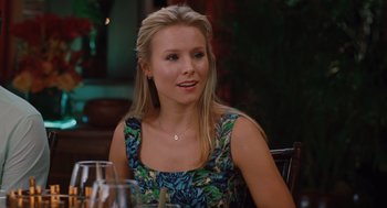 Movie still from “Couples Retreat” (2009), directed by Peter Billingsley – A woman sitting at a table with a glass of wine in front of her; Close Up shot, Over the shoulder angle