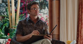 Movie still from “Couples Retreat” (2009), directed by Peter Billingsley – A man sitting in a chair writing on a notepad; Close Up shot, Low angle