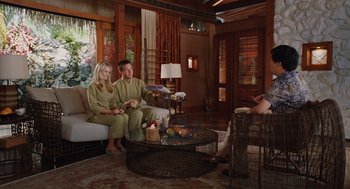 Movie still from “Couples Retreat” (2009), directed by Peter Billingsley – A man and a woman sitting on a couch in a living room; Wide shot, High angle