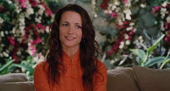 Movie still from “Couples Retreat” (2009), directed by Peter Billingsley – A woman sitting on top of a couch in front of flowers; Close Up shot, Over the shoulder angle