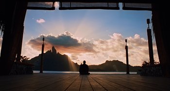 A person sitting on a dock looking at the sky