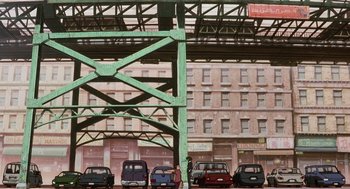Movie still from “Cowboy Bebop: The Movie” (2001), directed by Yoshiyuki Takei – Cars are parked under an overpass on a city street; Extreme Wide shot, Overhead angle