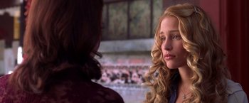Movie still from “Coyote Ugly” (2000), directed by David McNally – A woman sitting next to another woman in front of a fireplace; Close Up shot, Over the shoulder angle