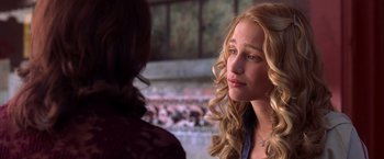 Movie still from “Coyote Ugly” (2000), directed by David McNally – A woman with long blonde curly hair is talking to another woman; Close Up shot, Over the shoulder angle
