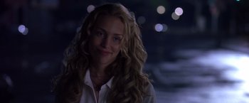 Movie still from “Coyote Ugly” (2000), directed by David McNally – A woman with long blonde curly hair smiling at the camera; Close Up shot, Over the shoulder angle