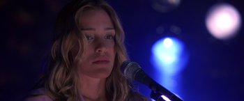 Movie still from “Coyote Ugly” (2000), directed by David McNally – A person holding a microphone; Close Up shot, Low angle