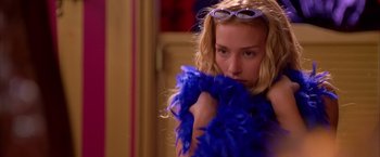Movie still from “Coyote Ugly” (2000), directed by David McNally – A woman in a blue feather boa and sunglasses; Close Up shot, Over the shoulder angle