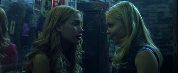 Movie still from “Coyote Ugly” (2000), directed by David McNally – Two young blonde women looking at one another in the mirror; Close Up shot, Over the shoulder angle