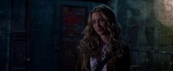 Movie still from “Coyote Ugly” (2000), directed by David McNally – A woman with long blonde curly hair standing in the dark; Medium shot, Over the shoulder angle