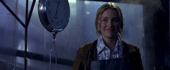 Movie still from “Coyote Ugly” (2000), directed by David McNally – A woman standing in front of a clock in a room; Medium shot, Low angle