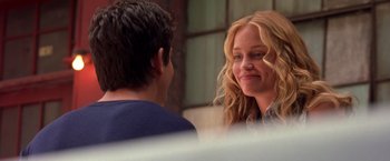 Movie still from “Coyote Ugly” (2000), directed by David McNally – A woman smiles at a man in a blue shirt; Close Up shot, Over the shoulder angle