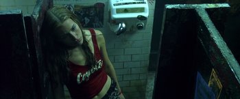 Movie still from “Coyote Ugly” (2000), directed by David McNally – A woman standing in front of a urinal in a bathroom; Medium shot, Low angle