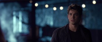 Movie still from “Coyote Ugly” (2000), directed by David McNally – A man in a black jacket is standing in front of a window; Close Up shot, Over the shoulder angle