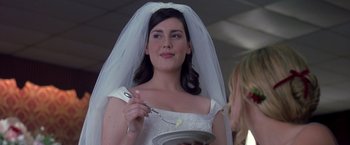 Movie still from “Coyote Ugly” (2000), directed by David McNally – A woman in a wedding dress holding a plate of food; Close Up shot, Over the shoulder angle