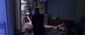 Movie still from “Coyote Ugly” (2000), directed by David McNally – A woman standing next to a man who is lying in a hospital bed; Wide shot, High angle