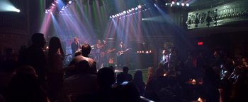 Movie still from “Coyote Ugly” (2000), directed by David McNally – A group of people on a stage with lights in the background; Wide shot, High angle
