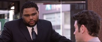 Movie still from “Cradle 2 the Grave” (2003), directed by Andrzej Bartkowiak – A man wearing a suit and tie sitting in front of a window; Close Up shot, High angle